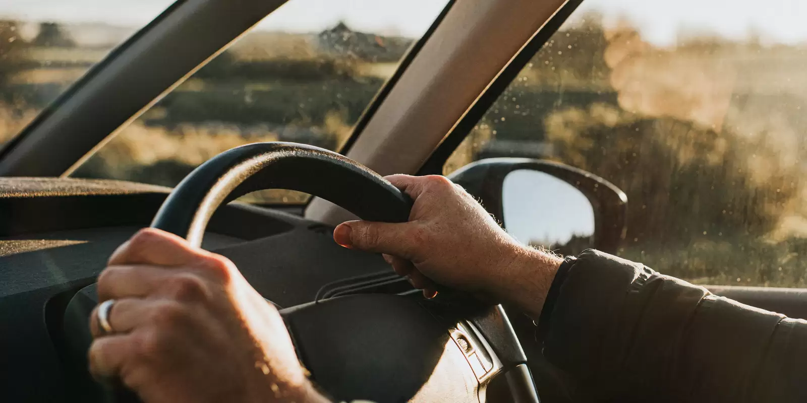Detalle de manos al volante de un coche del Grupo Volkswagen con un plan de mantenimiento y desgaste Long Drive Service 